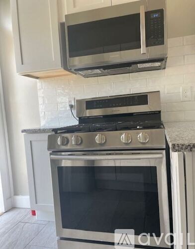 A kitchen with a stainless steel oven and microwave above it.