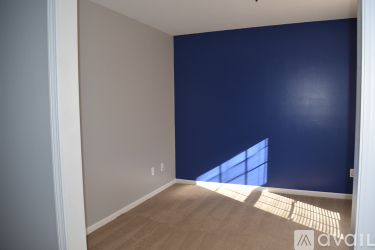 A room with a blue wall and wooden flooring.
