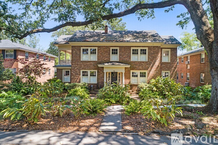 A house with a front yard and a tree in front of it.