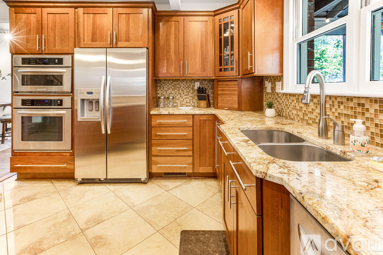 A kitchen with wooden cabinets and a granite countertop.