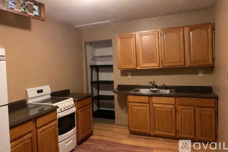 A kitchen with wooden cabinets and a white stove.