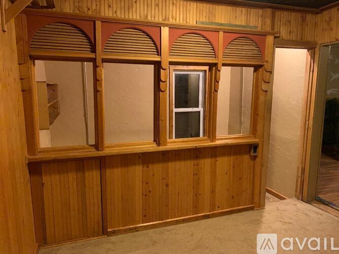 A wooden room with three windows and a door.