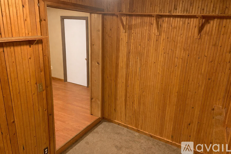 A wooden room with a door and a wall.