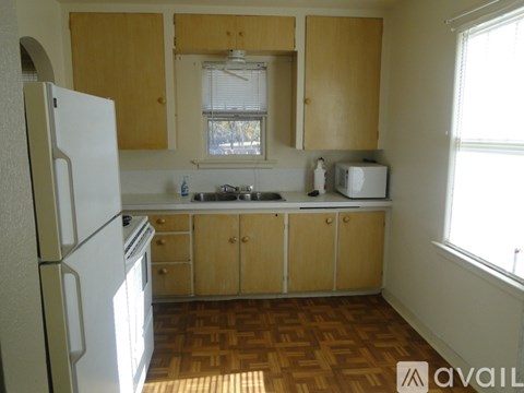 A kitchen with wooden cabinets and a white refrigerator.