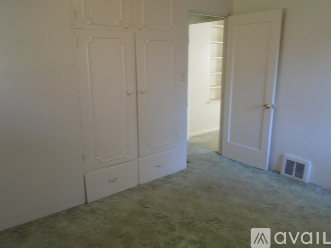 A room with white cupboards and a door.
