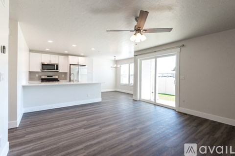 A spacious living room with a ceiling fan and sliding glass doors.
