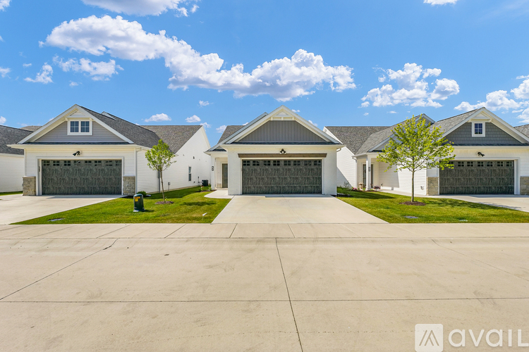 A row of houses with garages and driveways in front.