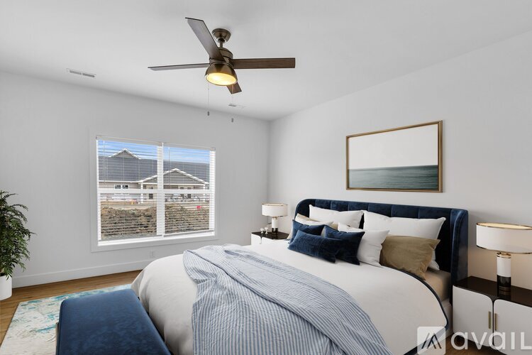 A bedroom with a large bed and a ceiling fan.