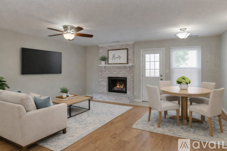A living room with a fireplace, a television, and a dining table.
