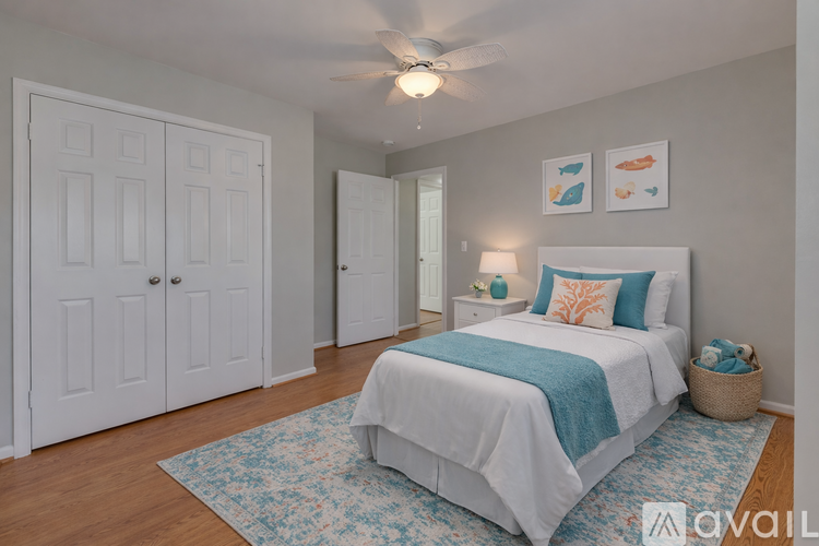 A bedroom with a bed, a ceiling fan, and a rug.