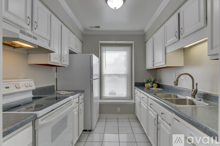A kitchen with white cabinets and appliances.