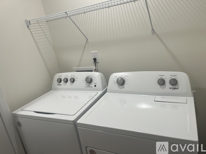 Two white Whirlpool washing machines are sitting next to each other.