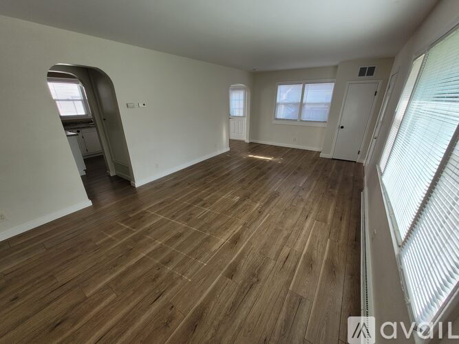 A room with wooden flooring and a large window.