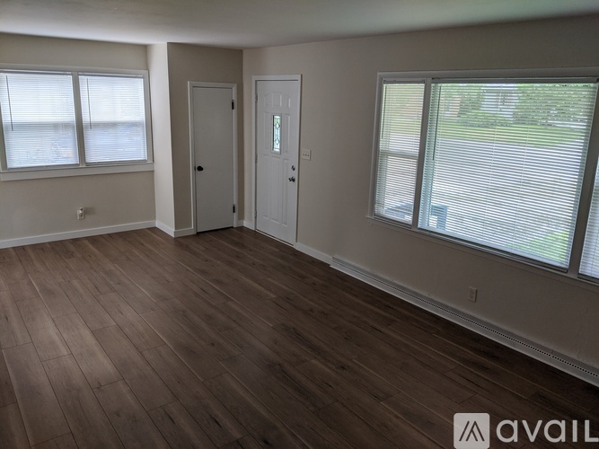 A room with wooden flooring and two doors.