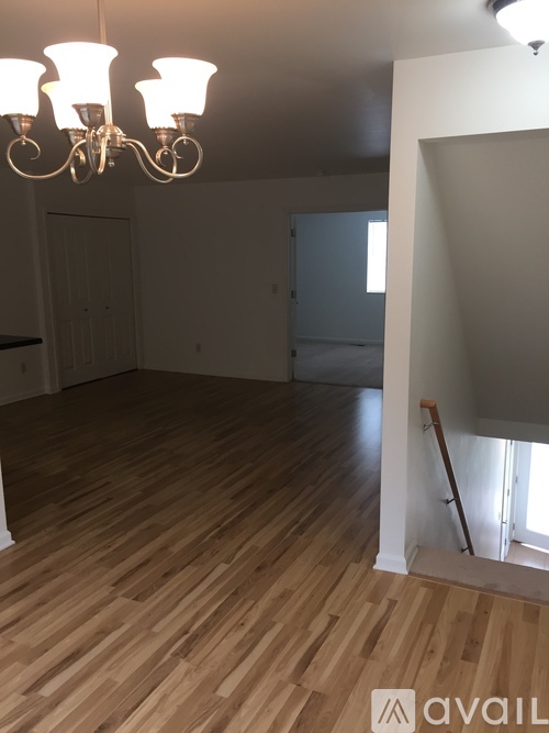 A room with wooden floors and a chandelier.