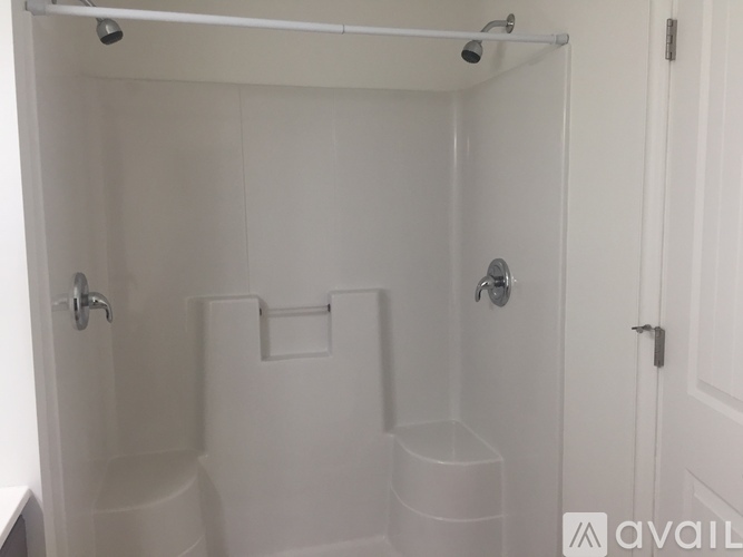 A white bathroom with a toilet, sink and shower.