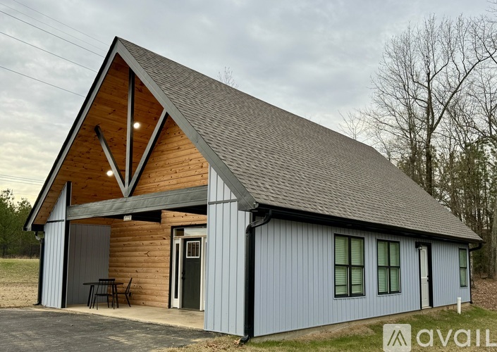 A wooden cabin with a porch and a covered entrance.