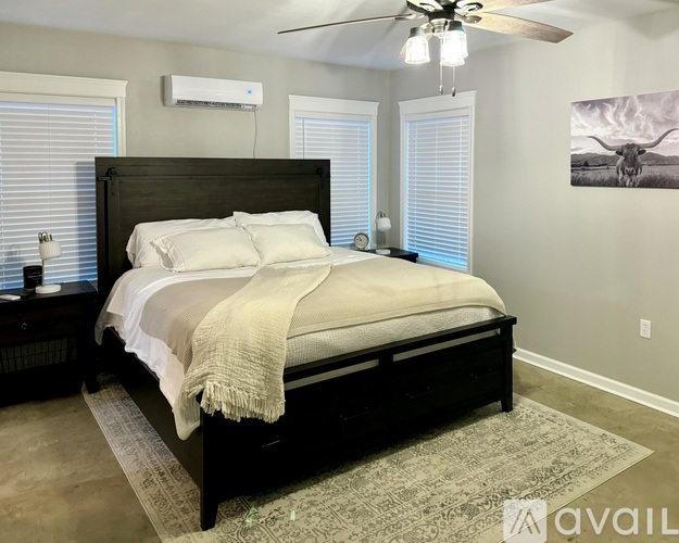 A bedroom with a large bed and a ceiling fan.
