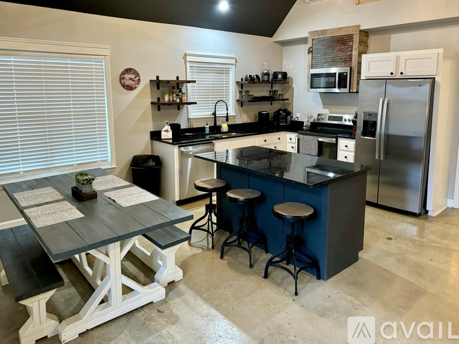 A kitchen with a black countertop and a table with a plant on it.