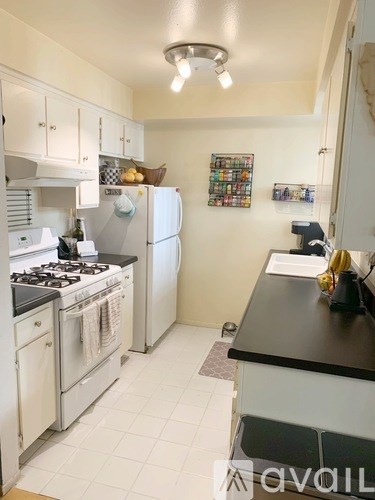 A kitchen with a white stove and a white refrigerator.