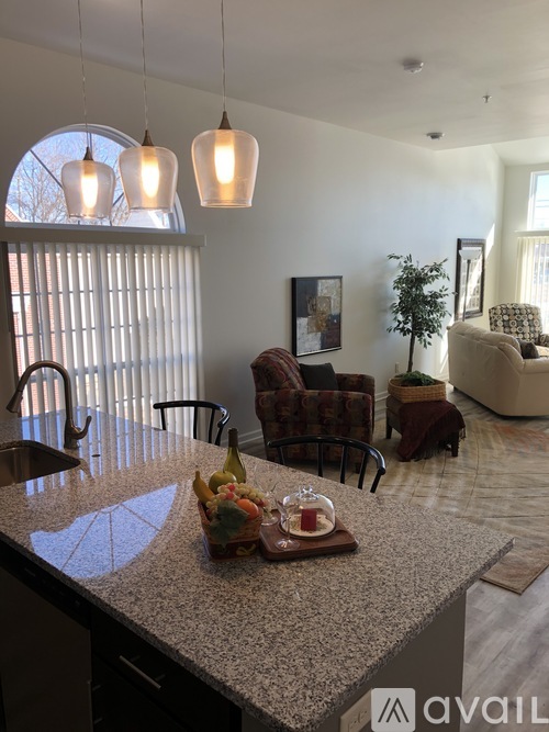 A kitchen with granite countertops and pendant lights.