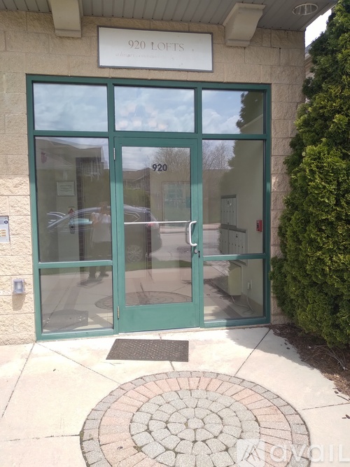 The front door of a building with a glass window and a green door.