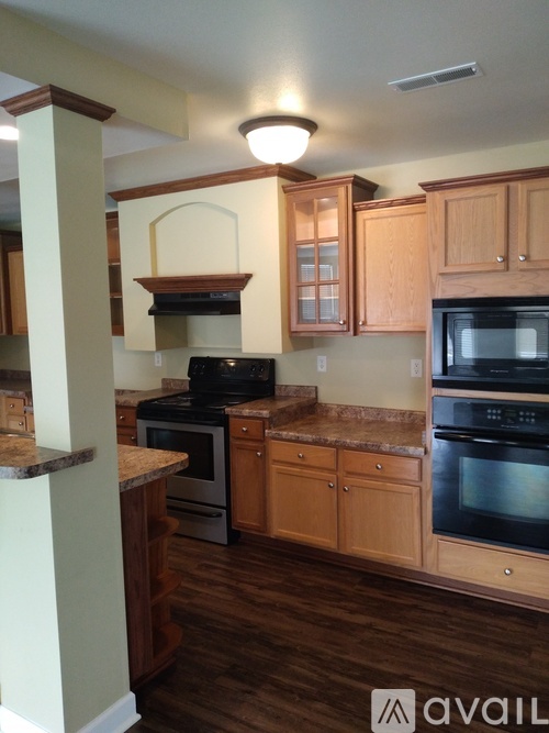 A kitchen with wooden cabinets and black appliances.