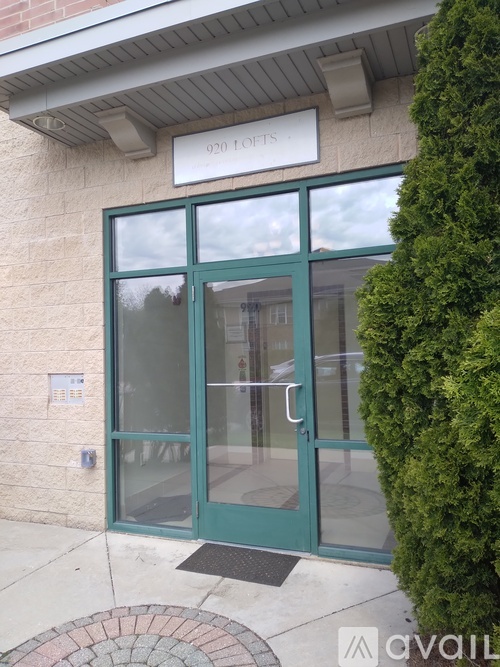 The front door of a building with a glass panel and a sign above it that reads "020 FOOTS".