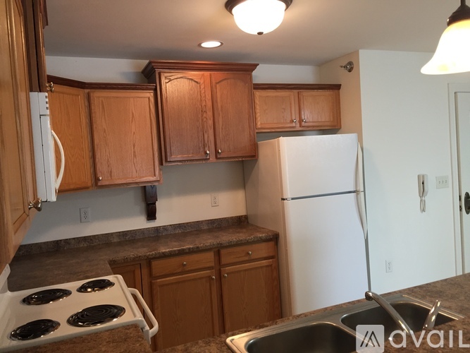 A kitchen with wooden cabinets and a white refrigerator.