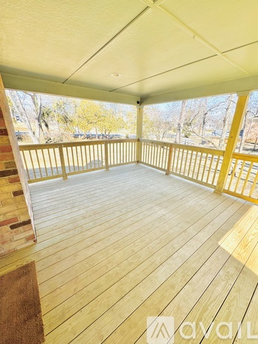 A wooden deck with a white ceiling and a brown rug.