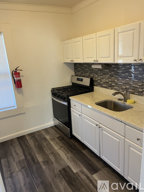 A kitchen with white cabinets and a black stove top oven.