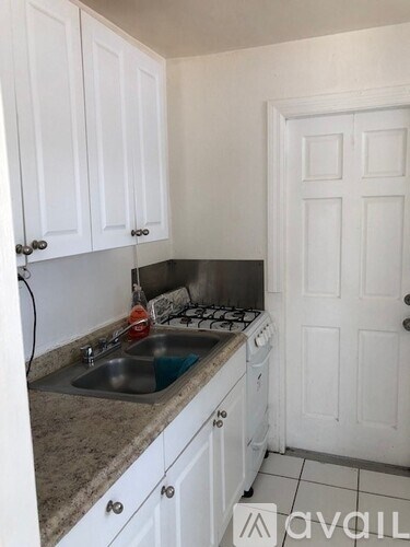 A kitchen with white cabinets and a granite countertop.