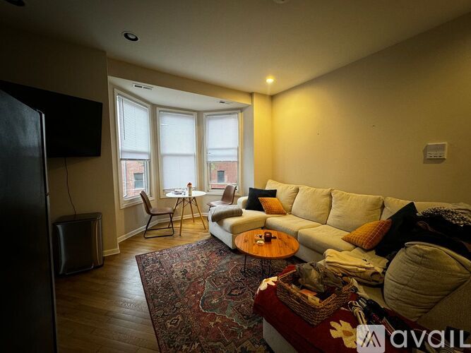 A living room with a couch, chair, and television.