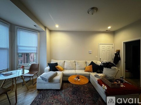 A living room with a white couch and a rug.