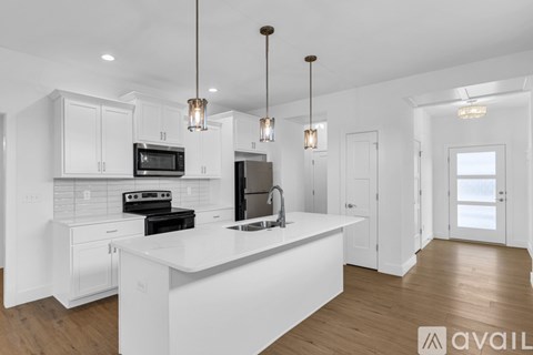 A modern kitchen with white cabinets and a central island.