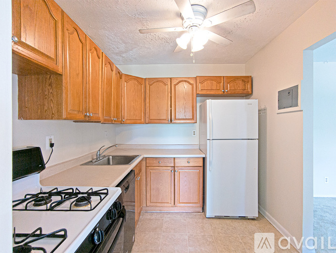 A kitchen with a white stove top oven and a white refrigerator.