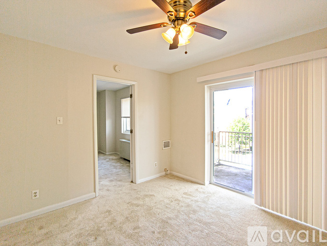 A room with a ceiling fan and carpeted floor.