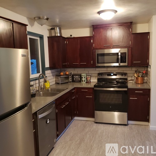 A kitchen with dark wood cabinets and stainless steel appliances.