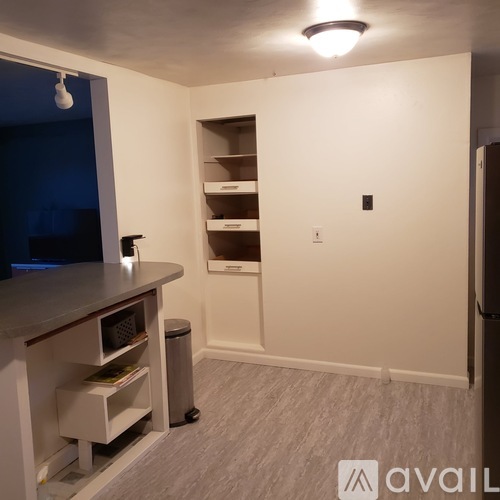 A kitchen area with a counter, microwave, and shelves.