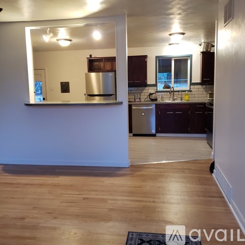 A kitchen with wooden floors and a large mirror on the wall.