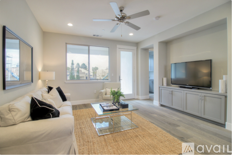 A living room with a white couch and a television on a cabinet.