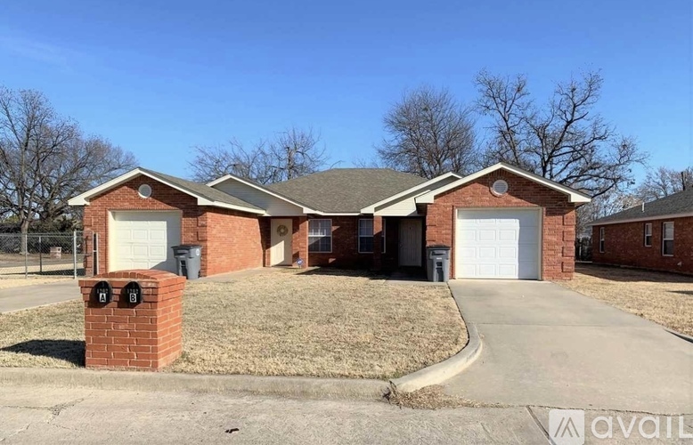 A house with a brick pillar in front of it.