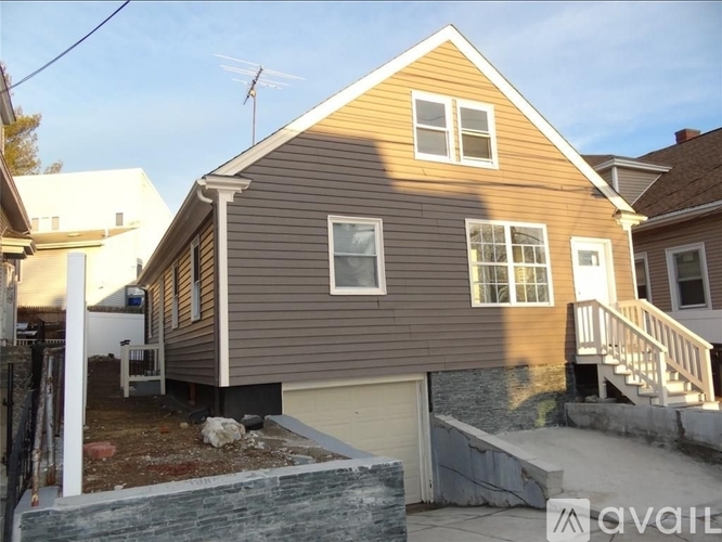 A two-story house with a garage and a balcony.