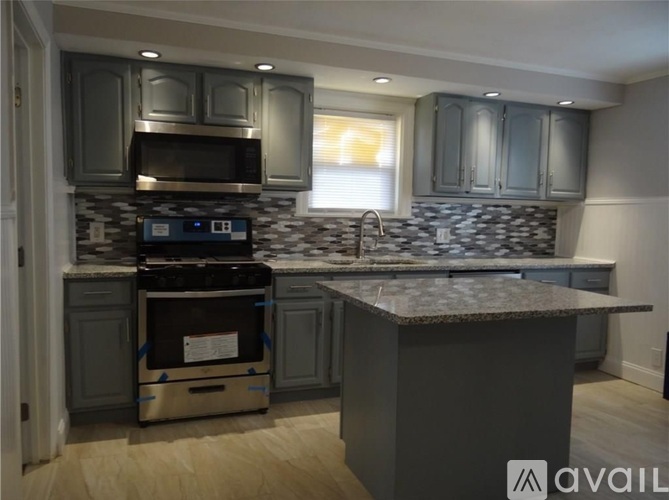 A kitchen with a granite countertop and a stove top oven.
