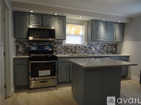 A kitchen with a granite countertop and a stove top oven.