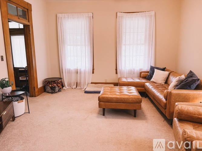 A living room with a brown leather couch and a wooden coffee table.