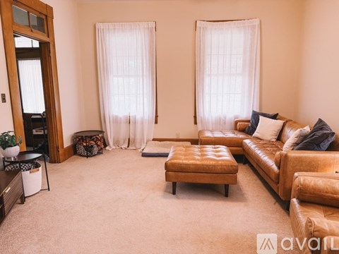 A living room with a brown leather couch and a wooden coffee table.