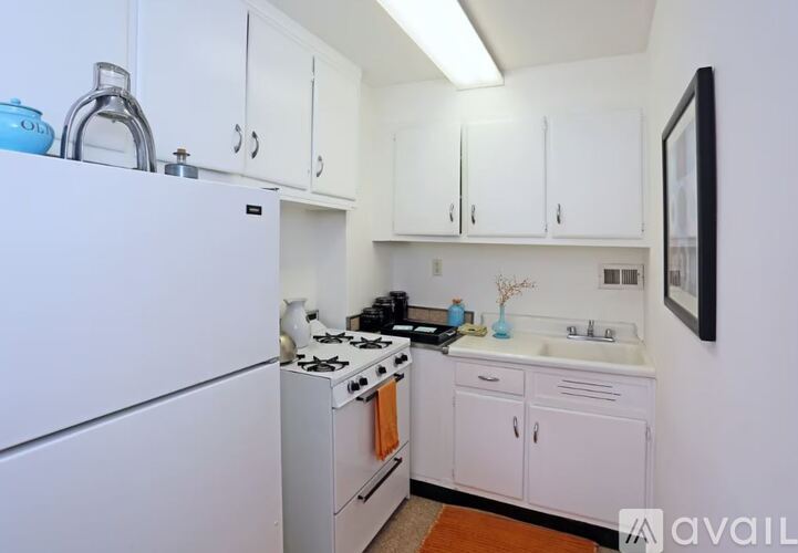 A kitchen with white appliances and cabinets.