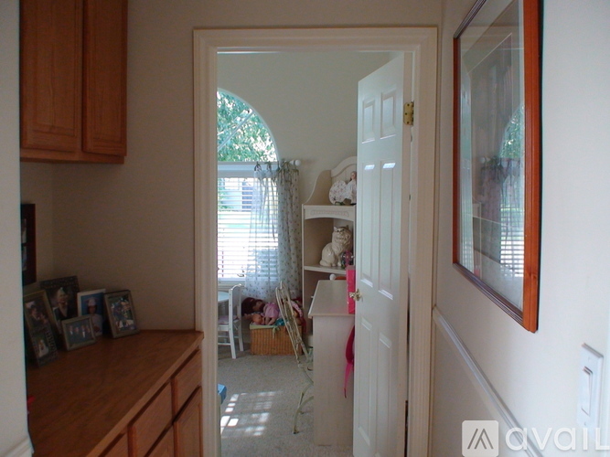 A white door with a pink ribbon tied to it.
