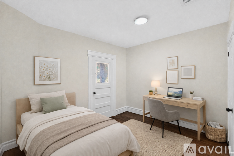 A bedroom with a bed, desk, and chair.